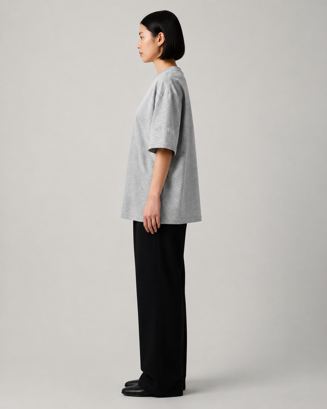 Model met oversized T-shirt, gemêleerd grijs — zijkant #heather-grey #gemêleerd-grijs